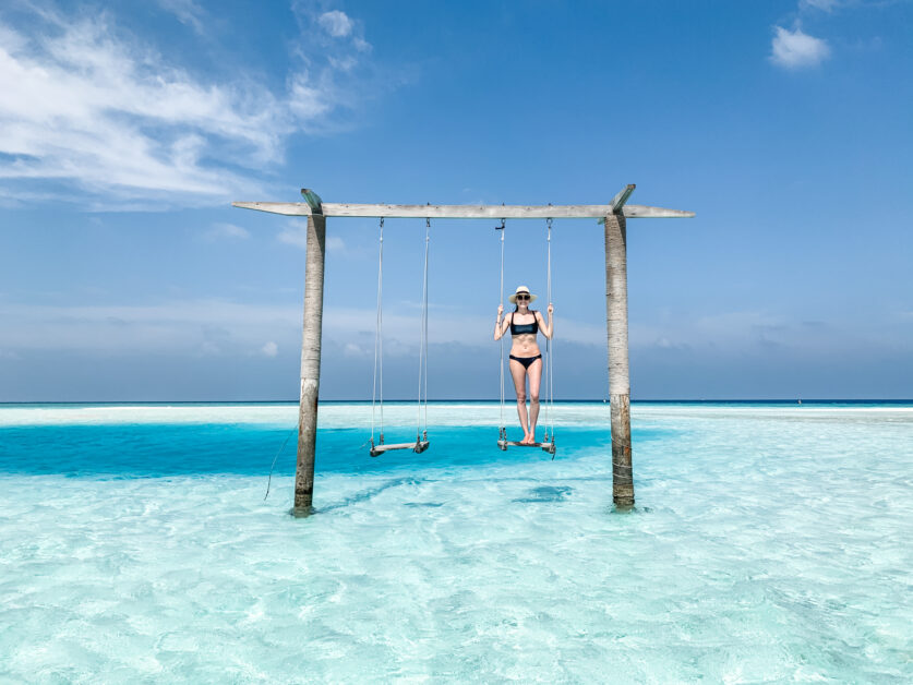 Lindsey standing on the swing in the middle of the Indian Ocean at Anantara Veli Maldives