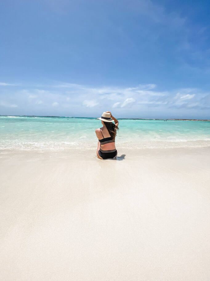 Visiting Aruba: Lindsey sitting at Baby Beach